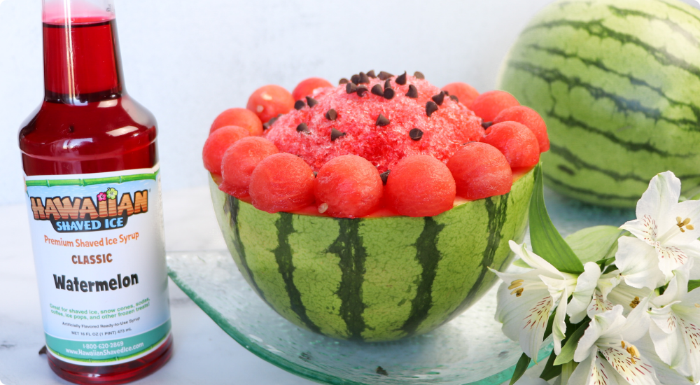 pint of watermelon shaved ice beside a watermelon bowl filled with shaved ice